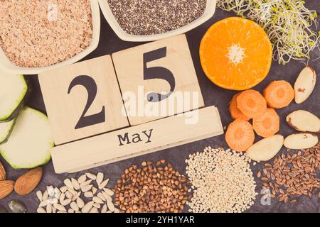 Calendario cubo con data del giorno Mondiale della tiroide e il miglior cibo contenente minerali naturali e vitamine per la tiroide sana Foto Stock