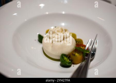 Burrata, un formaggio italiano a base di latte vaccino fatto di mozzarella e panna, servito su piatto Foto Stock