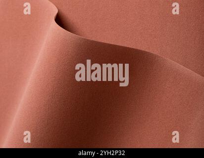 Sfondo in carta di design con una texture ricca e vellutata in calde tonalità terrose di auburn, arancio terroso e tawny. Questa superficie astratta presenta ondulati, Foto Stock