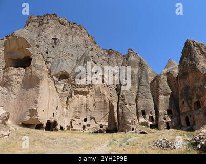 Rovine e Fairy Chimneys con sfondo Blue Sky e piante selvatiche a Selime, Aksaray, Turchia Foto Stock