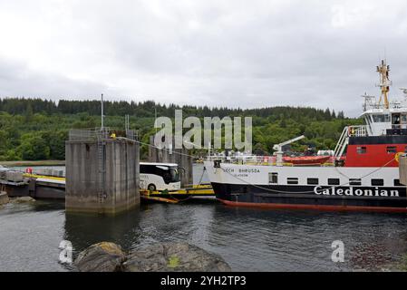 Un pullman turistico guida sul traghetto di Cal Mac Loch Bhrusda per Mallaig al porto di Armadale, Isola di Skye, Scozia, giugno 2024 Foto Stock