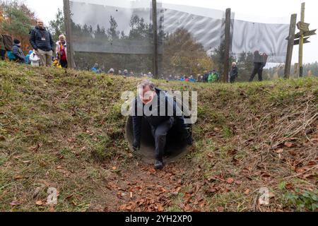 Wendehausen, Germania. 9 novembre 2024. Bodo Ramelow (Partito di sinistra), primo ministro facente funzioni della Turingia, strizza attraverso la sluice dell'agente sotto l'ex recinzione di confine interna tedesca che esiste ancora qui durante un'escursione lungo il Column Trail sulla Green Belt. Eventi commemorativi si tengono nello Stato libero per celebrare il 35° anniversario della caduta del muro. Credito: Michael Reichel/dpa/Alamy Live News Foto Stock