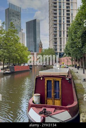 Salford, Manchester, regno unito, 17 agosto 2024, Canal Narrow Boat, ed edifici cittadini, nell'area di castlefield, a salford Foto Stock