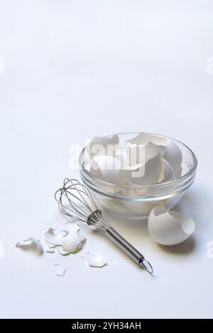 Conchiglie d'uovo nel recipiente di vetro e frusta Foto Stock