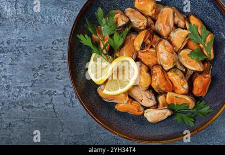 Cozze senza guscio, bollite, cozze, sbucciate, in un recipiente, con limone e prezzemolo, cozze cilene, vista dall'alto, niente persone Foto Stock