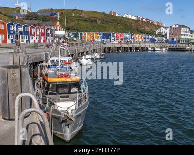 Piccole barche da pesca ormeggiate sulla riva nel porto interno e sullo sfondo case colorate protette dal patrimonio culturale, colorate baracche di aragosta Foto Stock