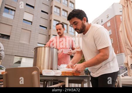 Valencia, Spagna - 9 novembre 2024. Vita quotidiana dopo la catastrofe DANA. Le persone sostengono le città colpite attraverso diverse azioni di aiuto. Il proprietario del ristorante MO e la sua cucina e preparazione per la consegna di cibo caldo fresco da inviare a diversi punti di controllo nell'area Ground zero. Le persone in questa zona spesso non possono lasciare la propria casa essendo anziane o a causa delle condizioni delle strade ancora ricoperte di fango. Aiutare le persone a preparare il cibo in tupati pronti per essere consegnati a chi ne ha bisogno. Crediti: Roberto Arosio/Alamy Live News Foto Stock