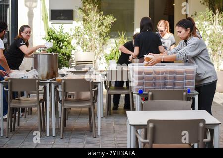 Valencia, Spagna - 9 novembre 2024. Vita quotidiana dopo la catastrofe DANA. Le persone sostengono le città colpite attraverso diverse azioni di aiuto. Il proprietario del ristorante MO e la sua cucina e preparazione per la consegna di cibo caldo fresco da inviare a diversi punti di controllo nell'area Ground zero. Le persone in questa zona spesso non possono lasciare la propria casa essendo anziane o a causa delle condizioni delle strade ancora ricoperte di fango. Aiutare le persone a preparare il cibo in tupati pronti per essere consegnati a chi ne ha bisogno. Crediti: Roberto Arosio/Alamy Live News Foto Stock