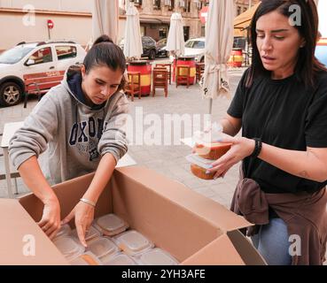 Valencia, Spagna - 9 novembre 2024. Vita quotidiana dopo la catastrofe DANA. Le persone sostengono le città colpite attraverso diverse azioni di aiuto. Il proprietario del ristorante MO e la sua cucina e preparazione per la consegna di cibo caldo fresco da inviare a diversi punti di controllo nell'area Ground zero. Le persone in questa zona spesso non possono lasciare la propria casa essendo anziane o a causa delle condizioni delle strade ancora ricoperte di fango. Aiutare le persone a preparare il cibo in tupati pronti per essere consegnati a chi ne ha bisogno. Crediti: Roberto Arosio/Alamy Live News Foto Stock