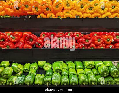 Peperoni freschi interi, maturi e colorati, arancio, rosso e verde Foto Stock