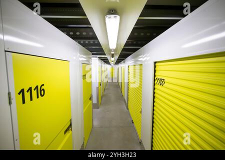 Armadietti di stoccaggio gialli numerati in una struttura ben illuminata, che offrono soluzioni di stoccaggio sicure e organizzate. Foto Stock