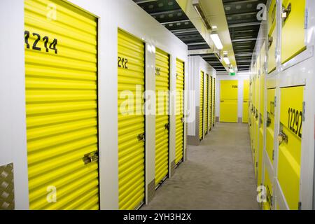 Armadietti di stoccaggio gialli numerati in una struttura ben illuminata, che offrono soluzioni di stoccaggio sicure e organizzate. Foto Stock