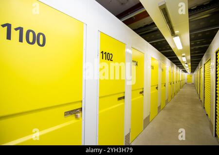Armadietti di stoccaggio gialli numerati in una struttura ben illuminata, che offrono soluzioni di stoccaggio sicure e organizzate. Foto Stock