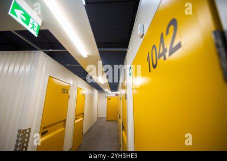 Armadietti di stoccaggio gialli numerati in una struttura ben illuminata, che offrono soluzioni di stoccaggio sicure e organizzate. Foto Stock