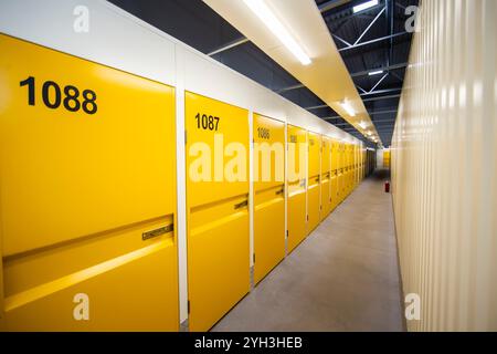 Armadietti di stoccaggio gialli numerati in una struttura ben illuminata, che offrono soluzioni di stoccaggio sicure e organizzate. Foto Stock