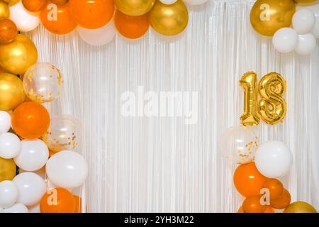 Palloncini colorati luminosi su sfondo bianco per un compleanno di diciotto anni. il numero 18. Foto Stock