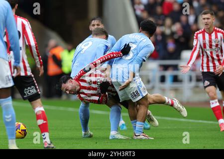 Patrick Roberts di Sunderland (centro) viene affrontato da Jay Dasilva di Coventry City (centro a destra) e Victor Torp durante la partita dello Sky Bet Championship allo Stadium of Light di Sunderland. Data foto: Sabato 9 novembre 2024. Foto Stock