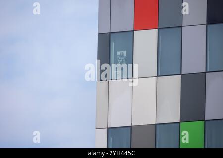 La fotografia raffigura una vista ravvicinata dell'angolo di un edificio moderno con una facciata colorata a griglia. Un edificio moderno con una facciata colorata Foto Stock