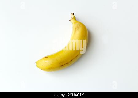 Un frutto nano di banana su sfondo bianco. Ingrediente organico ricco di vitamine per la dieta vegana. Frutta tropicale brasiliana. Foto Stock