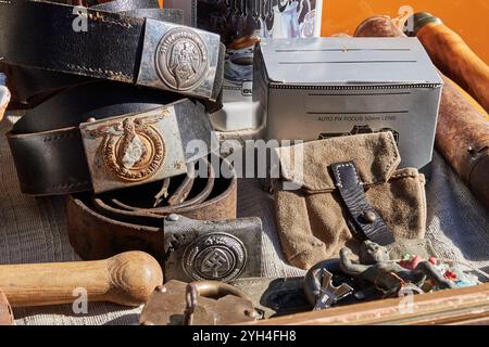 Trevi, Italia - 11 03 2024 - cinture e fibbie dei soldati tedeschi risalenti alla seconda guerra mondiale circondate da altre attrezzature militari, vendute a marchio delle pulci Foto Stock