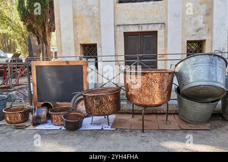 Trevi, Italia - 11 03 2024 - grandi recipienti in rame e acciaio, caldaie e pentole per bollire alimenti e cucinare formaggi, venduti in un mercato di Um Foto Stock