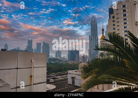 Vista dello skyline di Shanghai con lo Shanghai World Financial Center, grattacieli moderni e architettura tradizionale. Vegetazione lussureggiante e palme Foto Stock