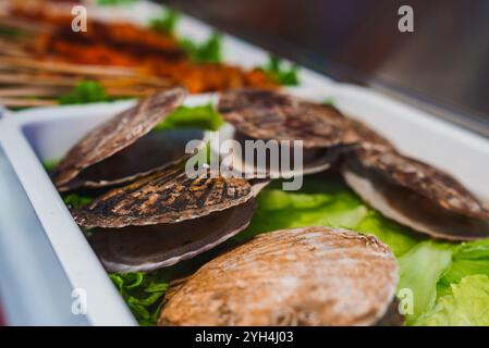 Primo piano di Scallop Shells sulla lattuga al mercato alimentare di Shanghai Foto Stock