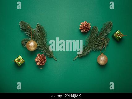 Decorazioni natalizie su rami di abete su sfondo verde che creano una forma di corna di renne che incornicia uno spazio vuoto Foto Stock