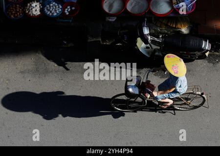 Hanoi, Vietnam - 13 luglio 2023: Donna vietnamita indossa il tradizionale cappello conico, noto come non la, usato per proteggere il viso dal sole caldo. Foto Stock