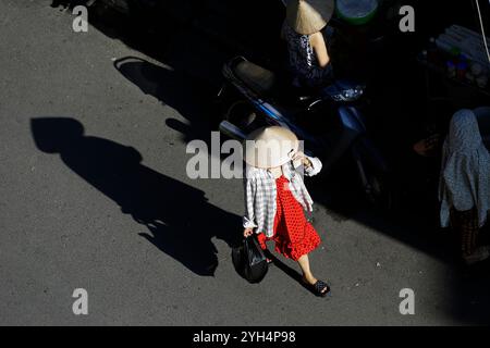 Hanoi, Vietnam - 13 luglio 2023: Donna vietnamita indossa il tradizionale cappello conico, noto come non la, usato per proteggere il viso dal sole caldo. Foto Stock