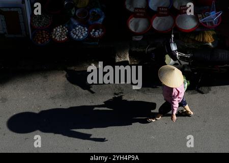 Hanoi, Vietnam - 13 luglio 2023: Donna vietnamita indossa il tradizionale cappello conico, noto come non la, per proteggere il viso dal sole caldo. Foto Stock