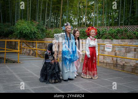 Individuali in tradizionale abbigliamento Cinese in un ambiente da Giardino di bambù Foto Stock