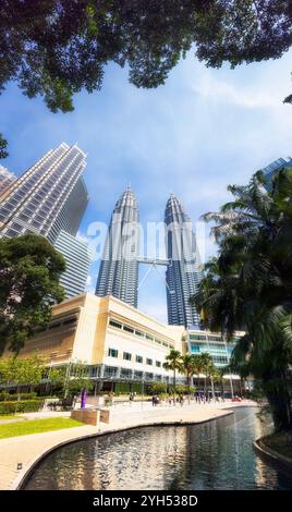 Panorama verticale a 180 gradi dalla piscina rinfrescante al cielo e agli alberi intorno alle alte torri a Kuala Lumpur, in Malesia. Foto Stock