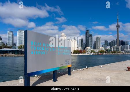 Cartellonistica dell'aeroporto Billy Bishop di Toronto City con lo skyline della città sulle Toronto Islands a Toronto, Ontario, Canada. Foto Stock