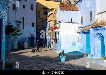 Chefchaouen, Marocco - 23 ottobre 2024: Due donne irriconoscibili con bagagli che si allontanano a medina a Chefchaouen, Marocco. Foto Stock