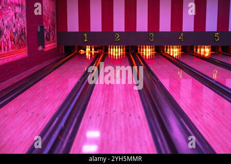 Piste da bowling con illuminazione al neon e birilli da bowling, per creare un'atmosfera vivace. Foto Stock