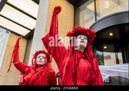 Londra, Regno Unito. 9 novembre 2024. I Red Rebels di Londra alzano i pugni di fronte all'edificio Shell durante la manifestazione. I Red Rebels di Londra, i London Drummers, Extinction Rebellion e gli Ogoni Solidarity si sono riuniti all'esterno dell'edificio Shell di Londra per manifestare in occasione del 29° anniversario della morte degli Ogoni Nine. Credito: SOPA Images Limited/Alamy Live News Foto Stock