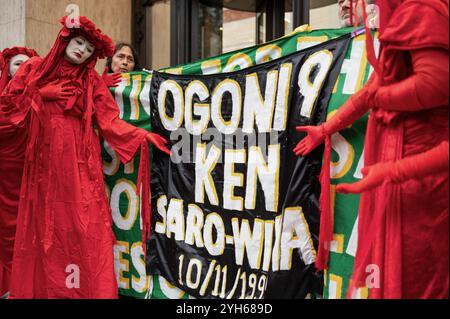 Londra, Regno Unito. 9 novembre 2024. I Red Rebels di Londra puntano ad uno striscione che commemora i nove Ogoni durante la manifestazione. I Red Rebels di Londra, i London Drummers, Extinction Rebellion e gli Ogoni Solidarity si sono riuniti all'esterno dell'edificio Shell di Londra per manifestare in occasione del 29° anniversario della morte degli Ogoni Nine. Credito: SOPA Images Limited/Alamy Live News Foto Stock