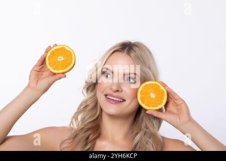 Una donna fresca e vibrante che tiene in mano una bella mostra di arance succose Foto Stock