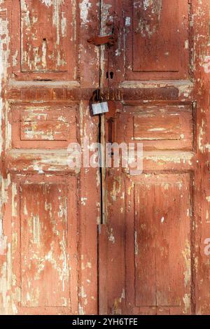 Vecchia porta tradizionale in legno verniciato con maniglia. Antico primo piano della porta d'ingresso chiusa in legno. Antica porta in legno dipinta di colore marrone. Vertica Foto Stock