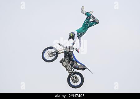 Il pilota Freestyle motocross FMX esegue un salto con la sua moto in alto nel cielo alla fiera motociclistica EICMA di Rho Fiera Milano a Milano, in Italia, il prossimo novembre Foto Stock