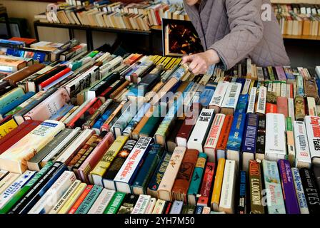 Persona anziana, pensionato di vecchiaia guarda attraverso una selezione di libri di seconda mano, una vendita di librerie. Petworth, West Sussex. Inghilterra 8 aprile 2006 2000s Regno Unito HOMER SYKES Foto Stock