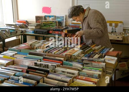 Donna anziana, pensionato di vecchiaia guarda attraverso una selezione di libri di seconda mano, una vendita di librerie. Petworth, West Sussex. Inghilterra 8 aprile 2006 2000s Regno Unito HOMER SYKES Foto Stock