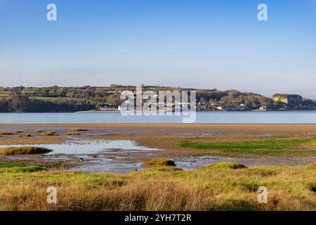 Vista dalla spiaggia di Pentraeth attraverso le paludi salate fino al villaggio di Red Wharf Bay. Isola di Anglesey, Galles, Regno Unito, Gran Bretagna Foto Stock