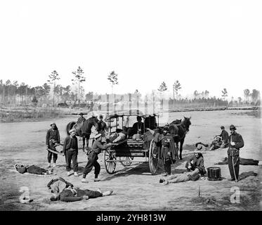 Ambulanza drill at Headquarters Army of Potomac, vicino a Brandy Station, Virginia., marzo 1864. L'equipaggio dell'ambulanza di Zouave dimostra la rimozione dei soldati feriti dal campo. Fotografato da William Frank Browne. Negativo in vetro, stereografo, collodion umido. Le mie ricerche personali suggeriscono che i soldati mostrati qui provengono dal 114° reggimento della Pennsylvania. Il particolare motivo di questa conclusione è il ricamo del polsino e dei pantaloni intorno alla tasca. Foto Stock