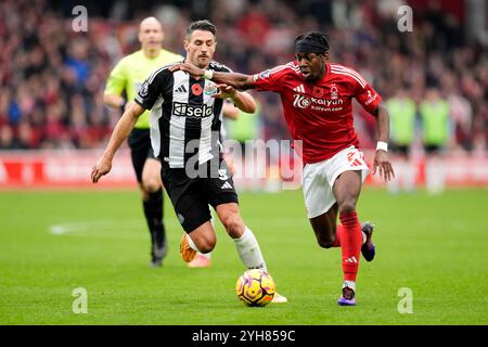 Anthony Elanga del Nottingham Forest e Fabian Schar (a sinistra) del Newcastle United si battono per il pallone durante la partita di Premier League al City Ground di Nottingham. Data foto: Domenica 10 novembre 2024. Foto Stock