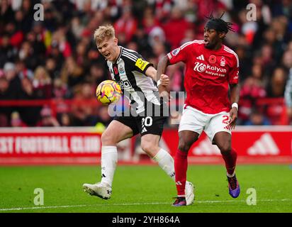 Lewis Hall del Newcastle United (a sinistra) e Anthony Elanga del Nottingham Forest si battono per il pallone durante la partita di Premier League al City Ground di Nottingham. Data foto: Domenica 10 novembre 2024. Foto Stock