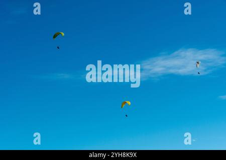 Tre parapendio sorvolano il cielo in una giornata luminosa e limpida Foto Stock