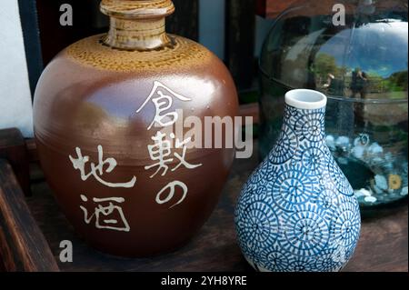 Mostra di negozi che presentano Kurashiki Jizake, Kurashiki locale sake vino di riso, in un negozio nel quartiere storico Bikan a Kurashiki, Okayama, Giappone. Foto Stock