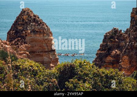Un gruppo di kayak pagaia tra le scogliere torreggianti di Ponta da Piedade Foto Stock